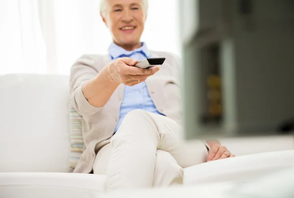 Close up of happy senior woman watching tv at home — Stock Photo, Image