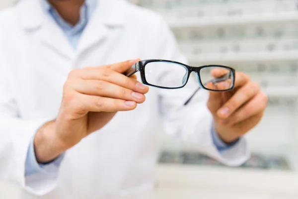 Primer plano del óptico con gafas en la tienda de óptica —  Fotos de Stock