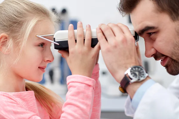 Optician with pupilometer and patient at eye clinic — Stock Photo, Image