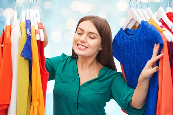 Mujer feliz eligiendo ropa en el armario — Foto de Stock