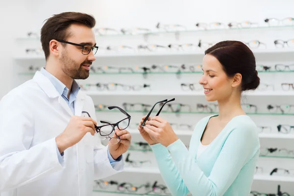 Žena a ukazující brýle v obchodě optika optik — Stock fotografie