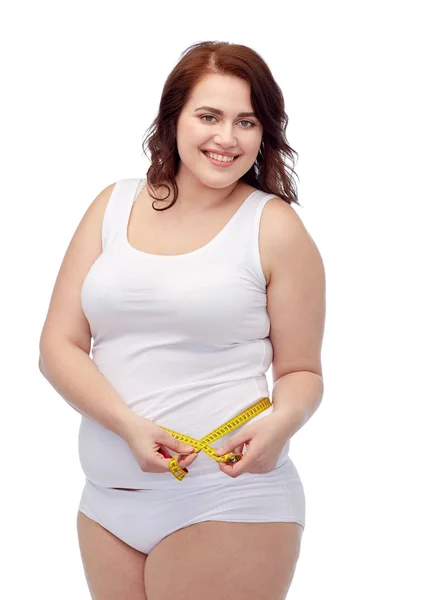 Feliz jovem plus size mulher com fita métrica — Fotografia de Stock