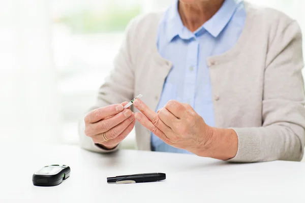 Femeie în vârstă cu glucometru verificarea zahărului din sânge — Fotografie, imagine de stoc