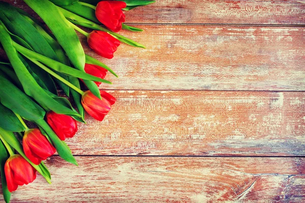 Nahaufnahme roter Tulpen auf hölzernem Hintergrund — Stockfoto