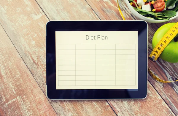 Close up of diet plan on tablet pc and food — Stock Photo, Image