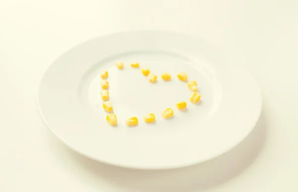 Close up de prato com milho em forma de coração — Fotografia de Stock
