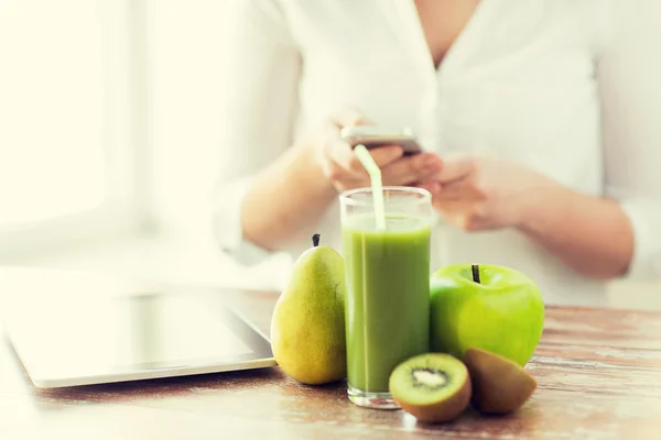 Close up of woman with smartphone and fruits — Stock Photo, Image