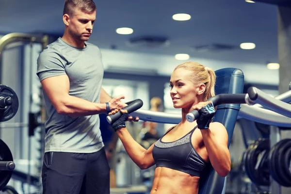 男人和女人展示肌肉健身房机器上 — 图库照片