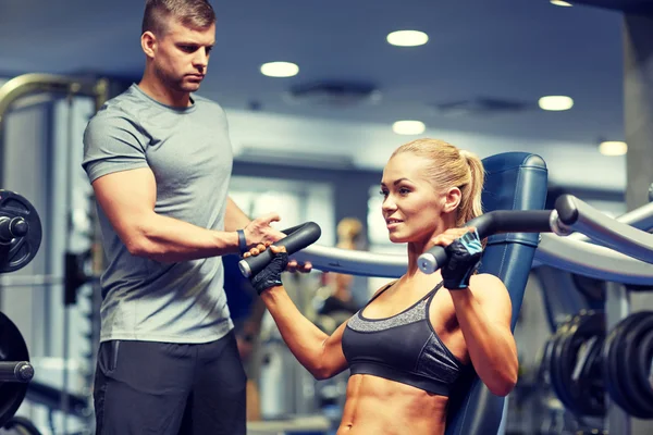 Hombres y mujeres flexionando los músculos en la máquina de gimnasio — Foto de Stock