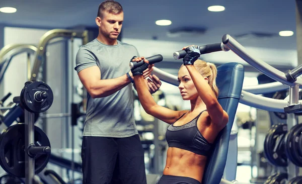 Muž a žena, protahuje svaly na posilovnu stroji — Stock fotografie
