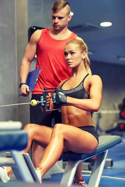 男人和女人展示肌肉健身房机器上 — 图库照片