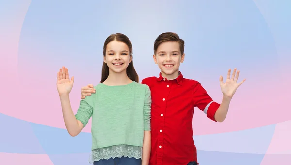 Gelukkige jongen en meisje zwaaien hand — Stockfoto