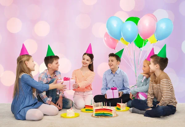 De gelukkige kinderen geven geschenken op verjaardagsfeestje — Stockfoto