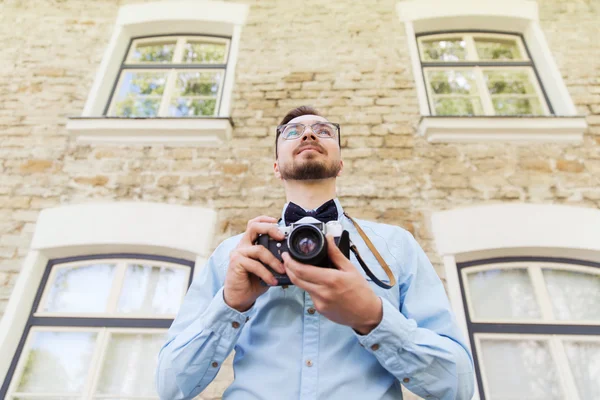 Gelukkig jonge hipster man met filmcamera in stad — Stockfoto