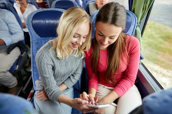 Seyahat otobüsündeki akıllı telefonlu mutlu genç kadınlar — Stok fotoğraf