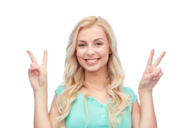 Smiling young woman or teenage girl showing peace Royalty Free Stock Images