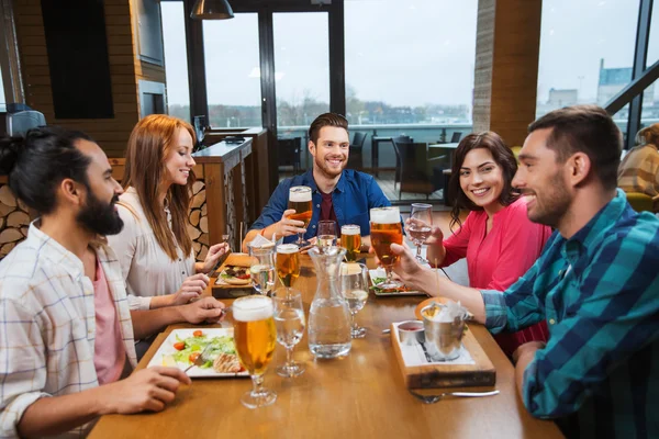 Vänner som äter och dricker öl på restaurang — Stockfoto