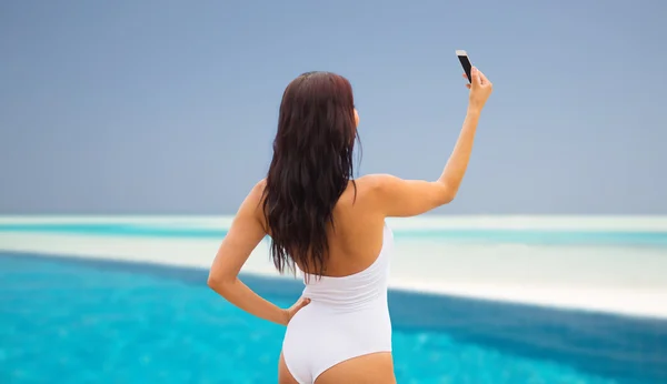 Genç bir kadın akıllı telefonuyla selfie çekiyor. — Stok fotoğraf