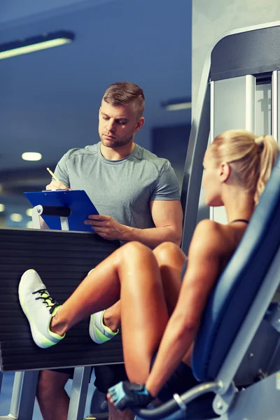 Man and woman flexing muscles on gym machine — Stock Photo, Image