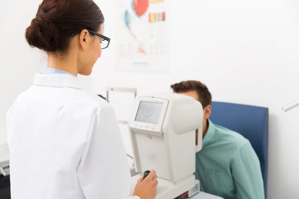 Optiker mit Autorefraktor und Patient in der Klinik — Stockfoto