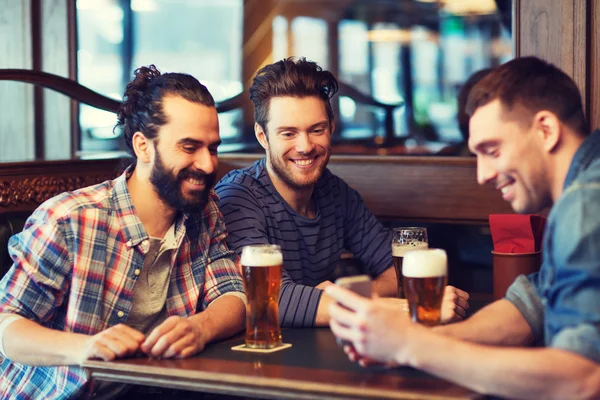 Teman laki-laki dengan smartphone minum bir di bar — Stok Foto