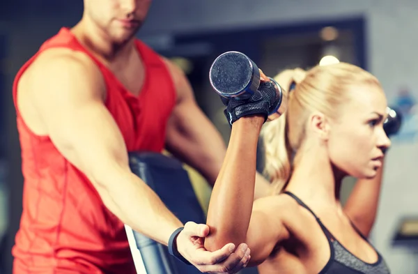 man and woman with dumbbells in gym