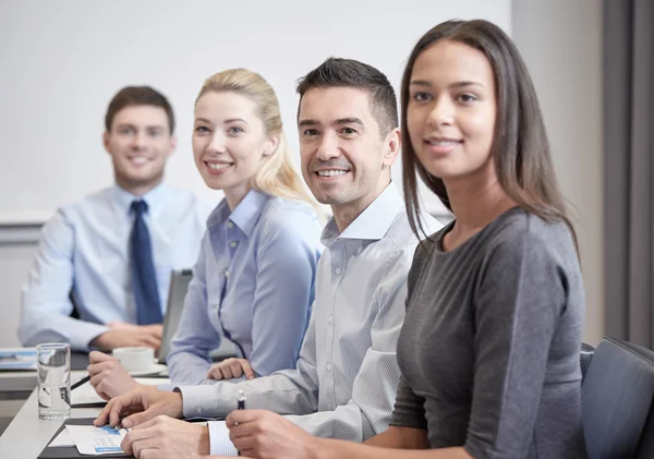 Группа улыбающихся бизнесменов, встречающихся в офисе — стоковое фото