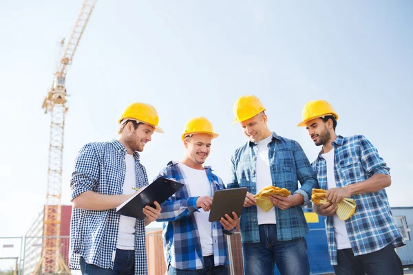 Grupo de constructores sonrientes con tableta pc al aire libre —  Fotos de Stock