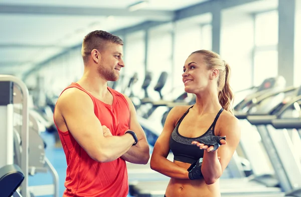 Smiling man and woman talking in gym — Stock Photo, Image