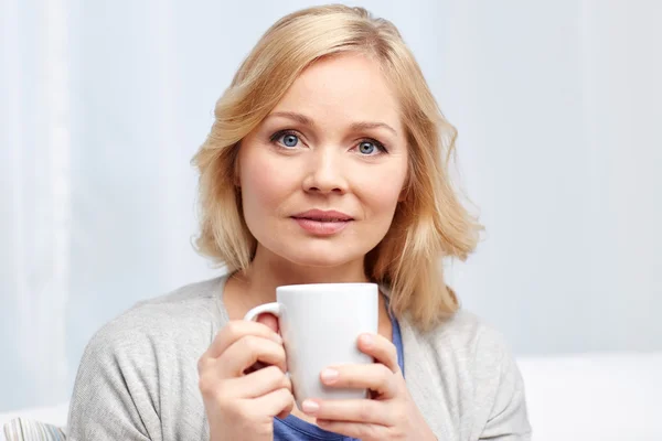 Vrouw met een kopje thee of koffie thuis — Stockfoto