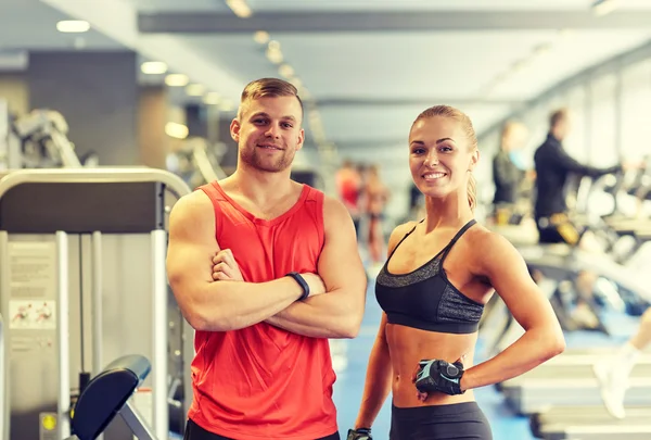 Sonriente hombre y mujer en el gimnasio —  Fotos de Stock