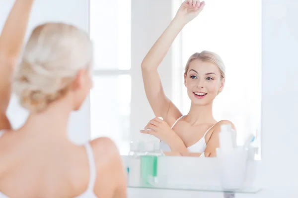 Woman with antiperspirant deodorant at bathroom — Stock Photo, Image