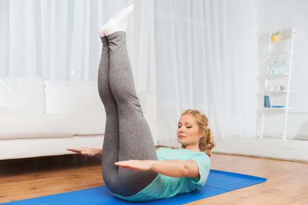 Woman exercising on mat at home — Stock Photo, Image