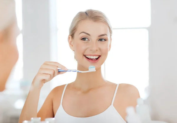 Donna con spazzolino da denti pulizia dei denti in bagno — Foto Stock