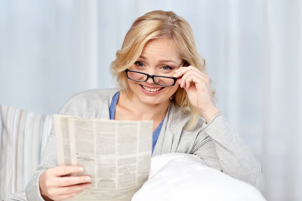 Frau mit Brille liest Zeitung zu Hause — Stockfoto