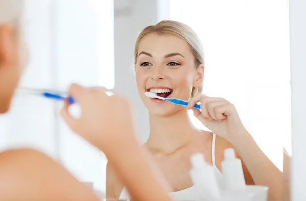 Donna con spazzolino da denti pulizia dei denti in bagno — Foto Stock