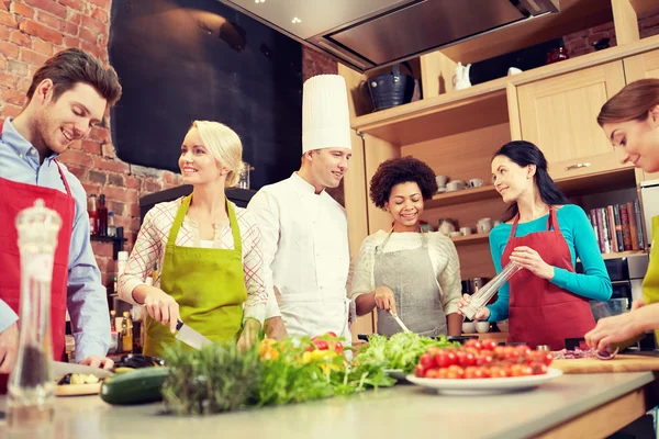 Amigos felices y cocinero cocinar en la cocina — Foto de Stock