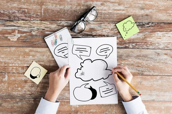 Close up of hands drawing text bubbles in notebook — Stock Photo, Image