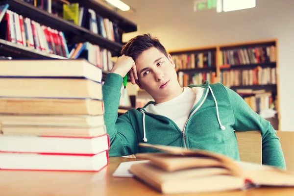 Estudante entediado ou jovem com livros na biblioteca — Fotografia de Stock