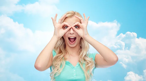 Young woman looking through finger glasses — Stock Photo, Image