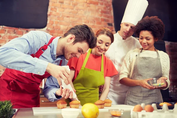 Amigos felizes e cozinheiro chef assar na cozinha — Fotografia de Stock