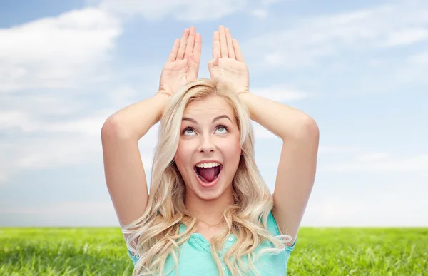 Gelukkig glimlachen jonge vrouw het maken van konijn oren — Stockfoto