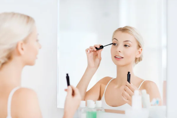 Kvinna med mascara tillämpas make upp badrum — Stockfoto