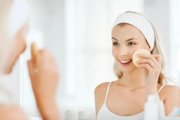 Mujer joven lavando la cara con esponja en el baño —  Fotos de Stock