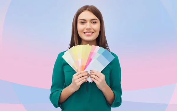 Smiling young woman with color swatches — Stock Photo, Image