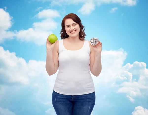 Size plus szczęśliwa kobieta wybierając jabłko lub cookie — Zdjęcie stockowe