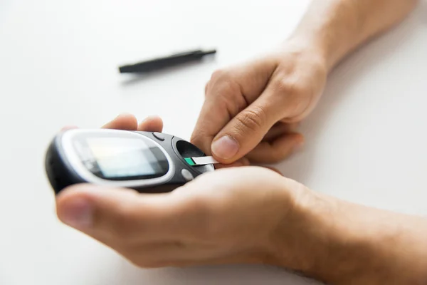 Close-up de homem verificando açúcar no sangue por Glucometer — Fotografia de Stock