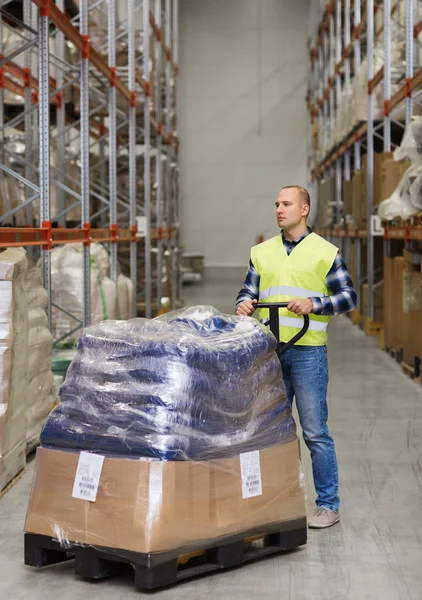 Man carrying loader with goods at warehouse — Stock Photo, Image
