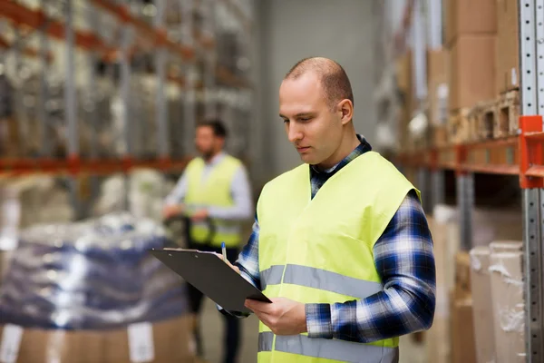 Adam güvenlik yeleği depo içinde clipboard ile — Stok fotoğraf