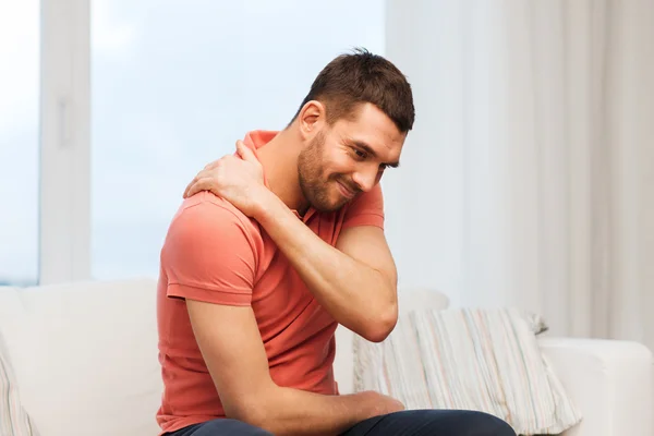 Unhappy man suffering from neck pain at home — Stock Photo, Image